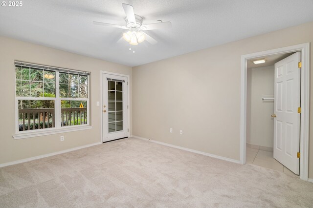 carpeted empty room featuring baseboards, a textured ceiling, and ceiling fan