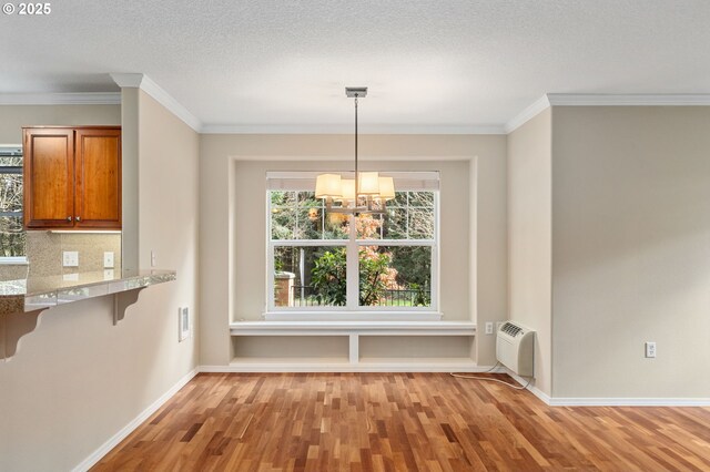 unfurnished dining area with an AC wall unit, light wood-style flooring, baseboards, and a chandelier