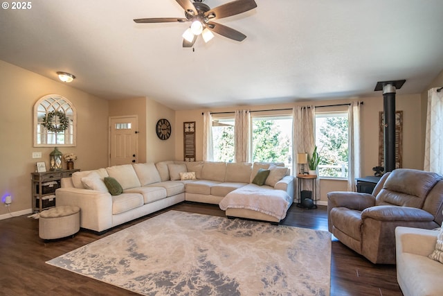 1950 Byron Creek Rd, Winston, OR 97496 - living area with dark wood finished floors, a ceiling fan, baseboards, and a wood stove