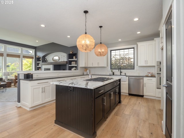 7882 SW Cinnabar, Wilsonville, OR 97070 - kitchen featuring appliances with stainless steel finishes, white cabinets, a chandelier, healthy amount of natural light, and recessed lighting