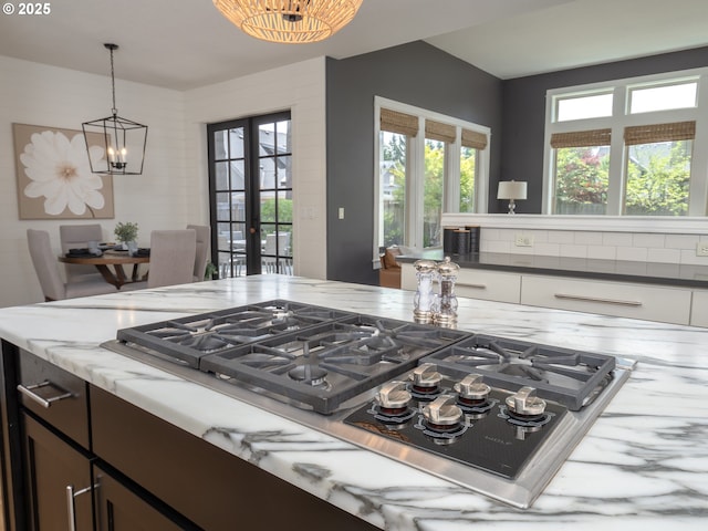 7882 SW Cinnabar, Wilsonville, OR 97070 - kitchen featuring stainless steel gas stovetop, light stone counters, a chandelier, hanging light fixtures, and french doors