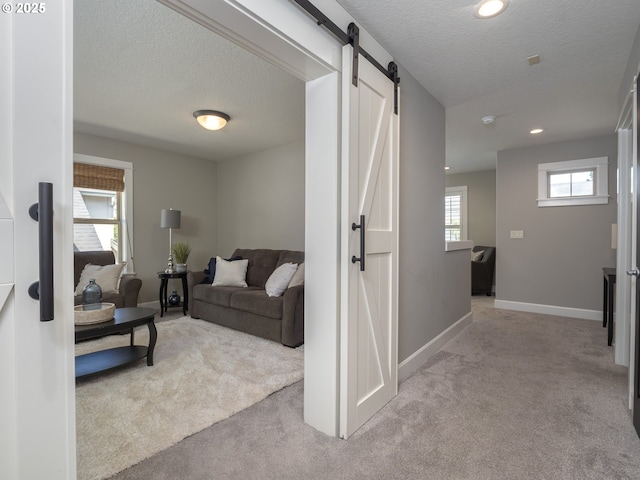 7882 SW Cinnabar, Wilsonville, OR 97070 - living area with carpet flooring, a barn door, a textured ceiling, and recessed lighting