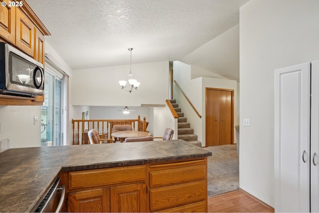 17701 Koch Ct, Sandy, OR 97055 - kitchen featuring stainless steel appliances, dark countertops, lofted ceiling, a peninsula, and a chandelier