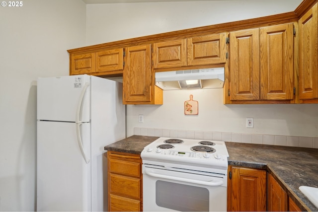 17701 Koch Ct, Sandy, OR 97055 - kitchen with white appliances, under cabinet range hood, dark countertops, and brown cabinets