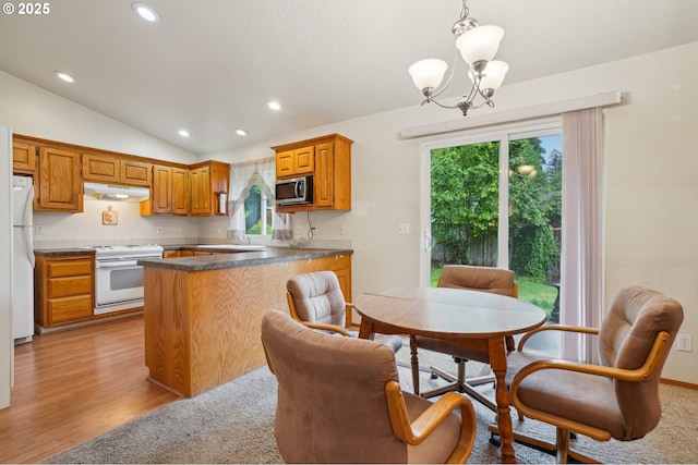 17701 Koch Ct, Sandy, OR 97055 - kitchen featuring white appliances, under cabinet range hood, dark countertops, lofted ceiling, and a chandelier
