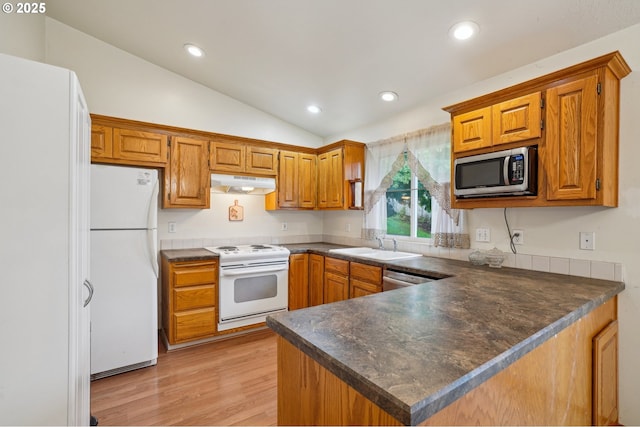 17701 Koch Ct, Sandy, OR 97055 - kitchen with white appliances, under cabinet range hood, dark countertops, lofted ceiling, and a peninsula