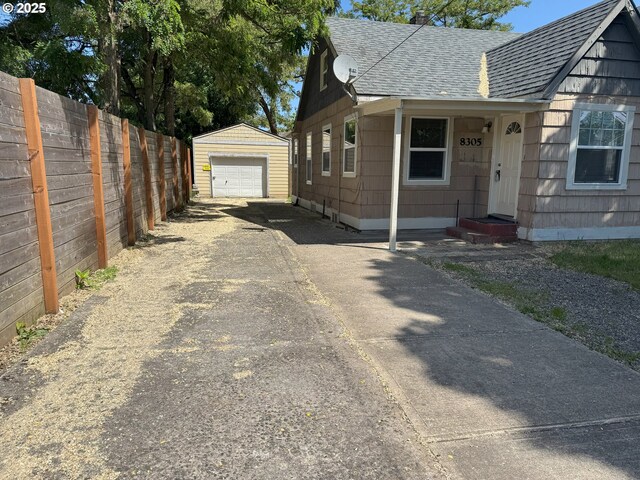 8305 SE Rhone St, Portland, OR 97266 - view of side of home with a shingled roof, driveway, an outbuilding, and a garage