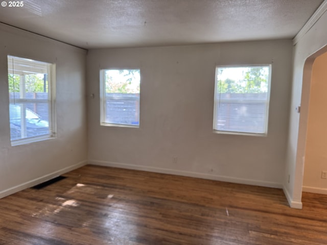 8305 SE Rhone St, Portland, OR 97266 - spare room with wood finished floors, plenty of natural light, baseboards, and a textured ceiling