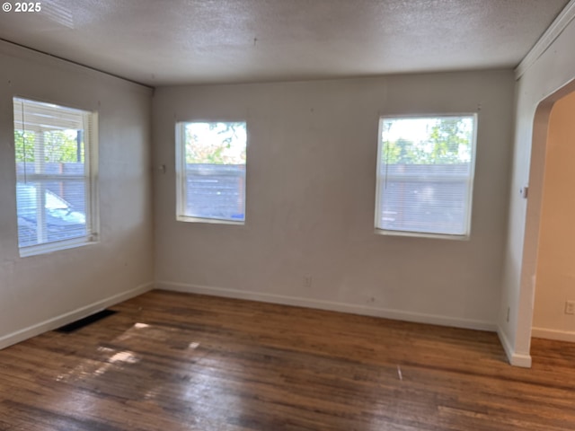 8305 SE Rhone St, Portland, OR 97266 - unfurnished room with wood finished floors, baseboards, arched walkways, and a textured ceiling
