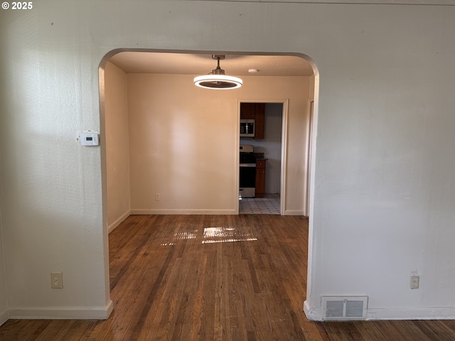 8305 SE Rhone St, Portland, OR 97266 - hallway featuring arched walkways, wood finished floors, and baseboards
