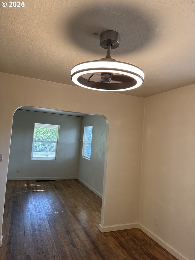 8305 SE Rhone St, Portland, OR 97266 - spare room featuring wood finished floors, arched walkways, baseboards, and a textured ceiling