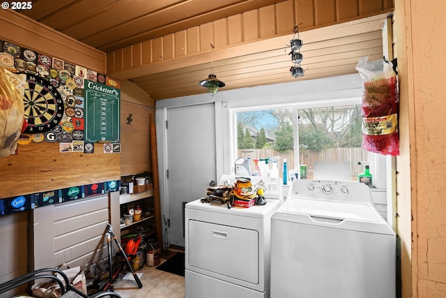 washroom featuring separate washer and dryer, wood ceiling, and wood walls