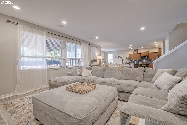 living room featuring recessed lighting, light wood-style floors, and baseboards
