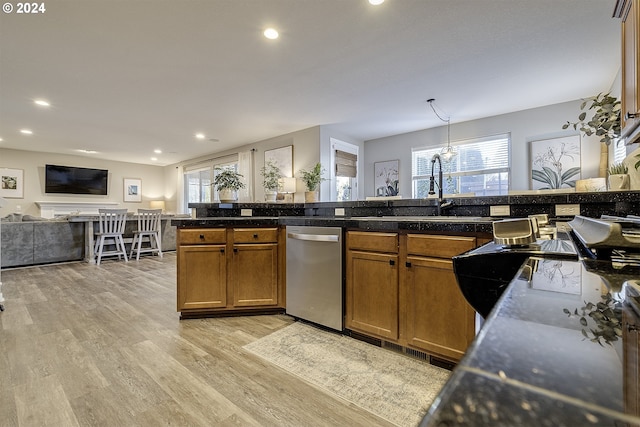kitchen featuring stainless steel dishwasher, tile counters, brown cabinetry, open floor plan, and light wood-style flooring