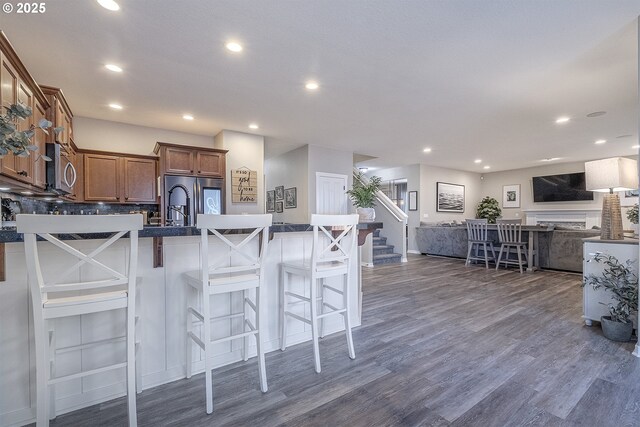 kitchen featuring stainless steel appliances, open floor plan, recessed lighting, and brown cabinetry