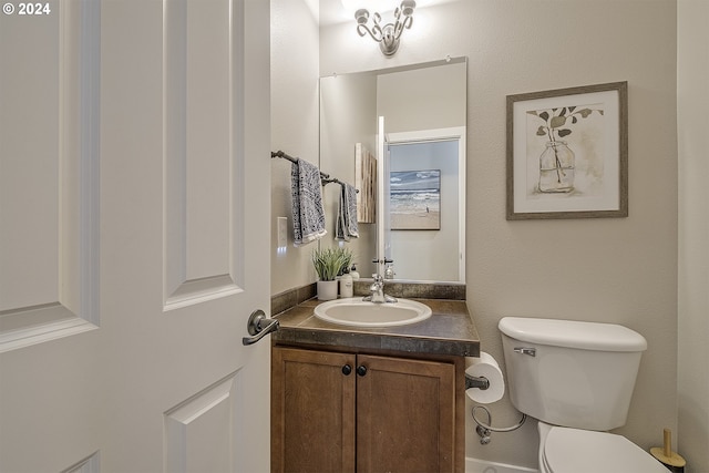 half bathroom featuring vanity and toilet