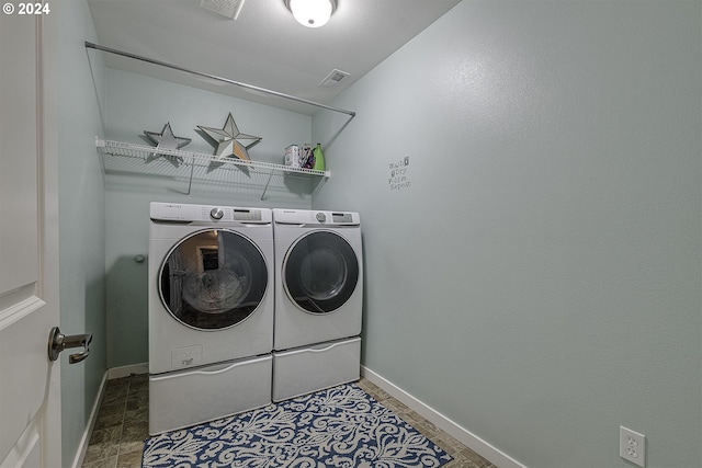 washroom featuring independent washer and dryer, visible vents, baseboards, and laundry area