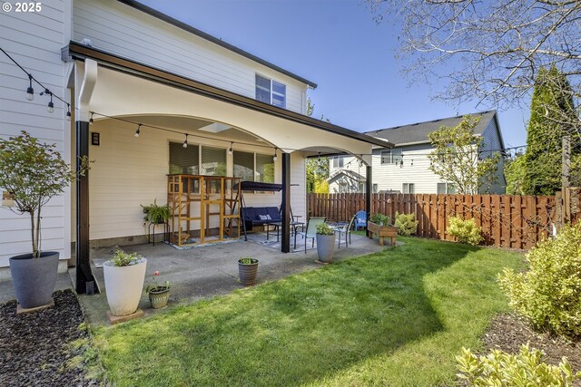 back of house featuring a yard, fence, and a patio area