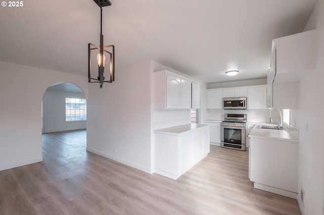 kitchen with light wood-type flooring, stainless steel appliances, sink, and white cabinets