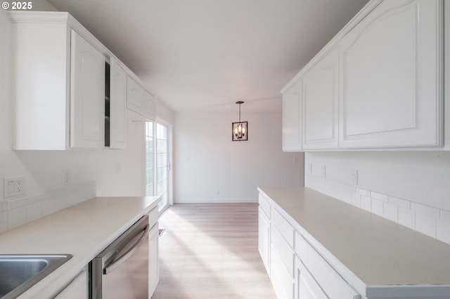 kitchen featuring stainless steel dishwasher, light hardwood / wood-style floors, hanging light fixtures, and white cabinets