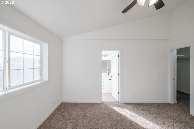 empty room featuring vaulted ceiling, light colored carpet, and ceiling fan