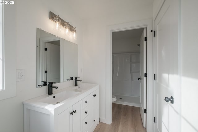 bathroom with vanity, hardwood / wood-style flooring, toilet, and walk in shower