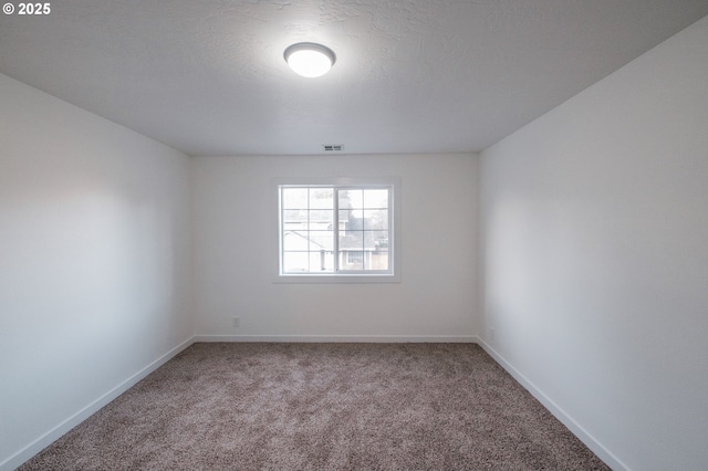 carpeted spare room with a textured ceiling