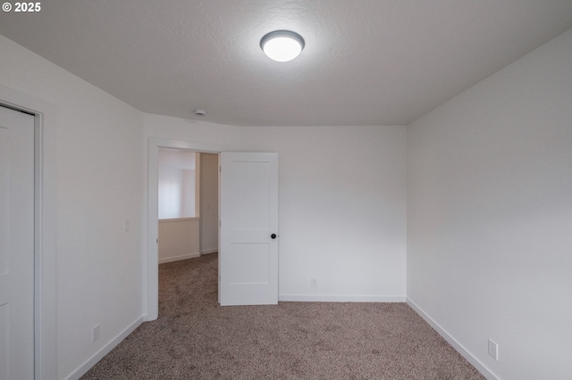 carpeted empty room featuring a textured ceiling