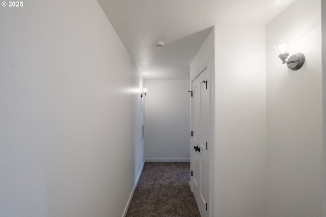 hallway featuring dark colored carpet