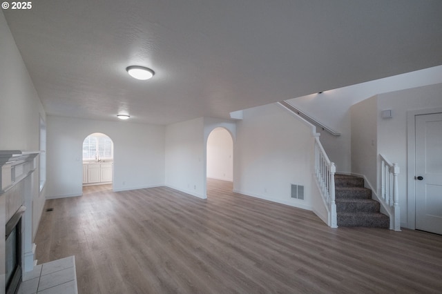 unfurnished living room featuring light wood-type flooring, sink, and a fireplace