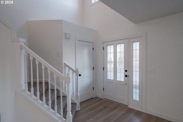 entrance foyer featuring hardwood / wood-style flooring and a towering ceiling