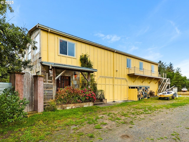 back of property featuring board and batten siding and fence