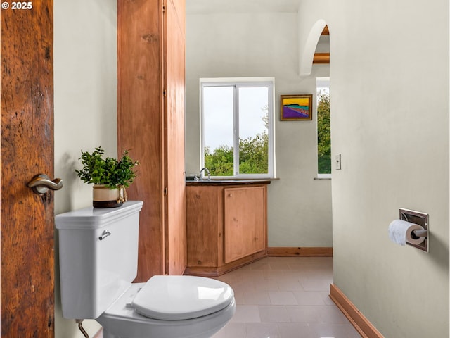 bathroom featuring toilet, baseboards, and tile patterned flooring