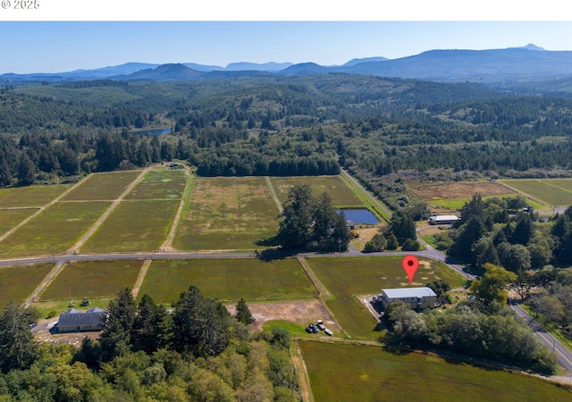drone / aerial view featuring a view of trees, a mountain view, and a rural view