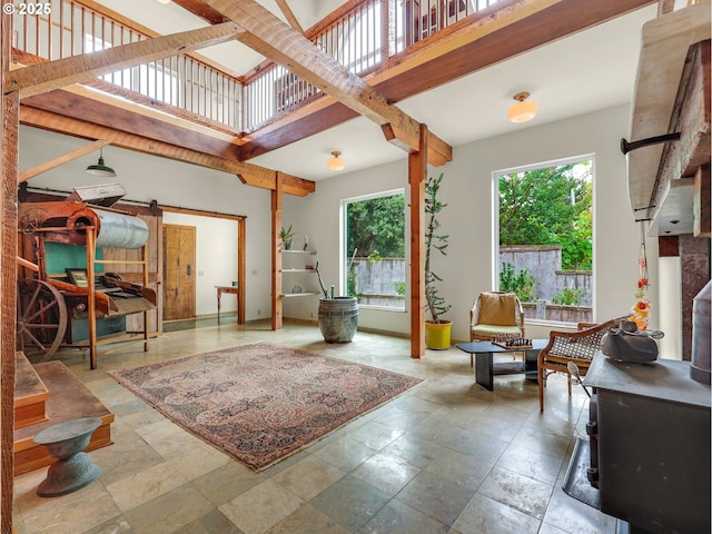 interior space featuring stone finish floor, a high ceiling, and a barn door
