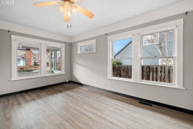 spare room with wood-type flooring and a healthy amount of sunlight