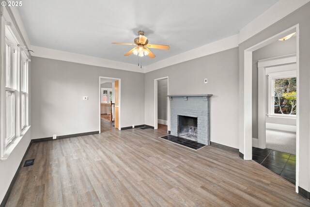 unfurnished living room featuring ceiling fan, a fireplace, and light hardwood / wood-style floors