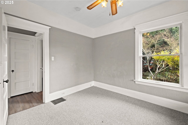 carpeted spare room featuring ceiling fan