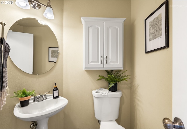 half bathroom featuring a sink and toilet