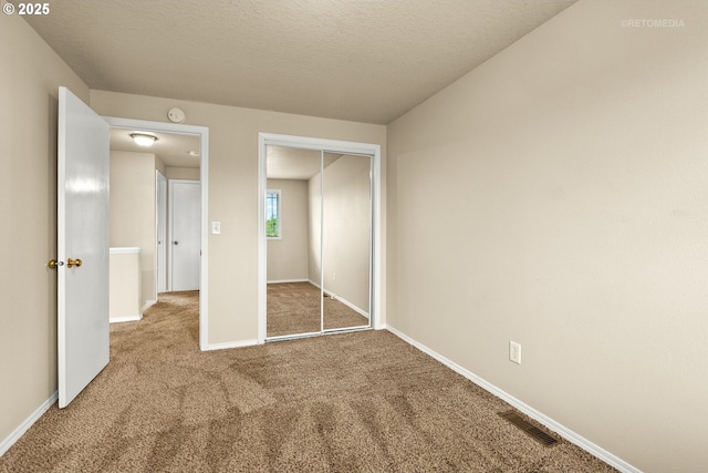 unfurnished bedroom featuring carpet flooring, a closet, and baseboards