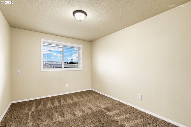 empty room featuring carpet floors, baseboards, and a textured ceiling