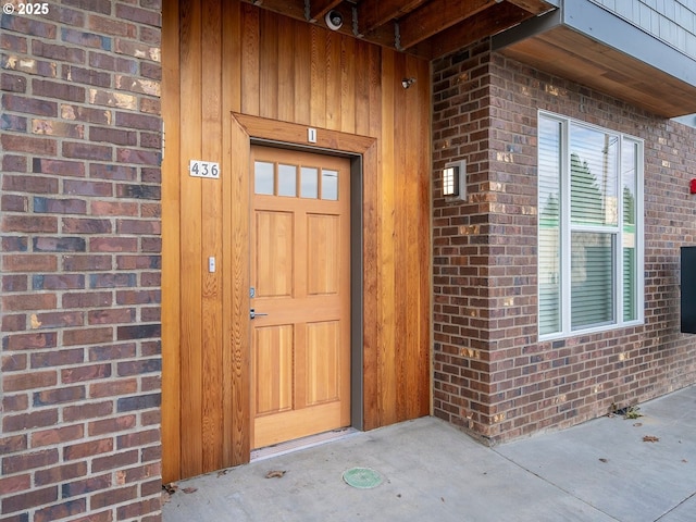 doorway to property featuring brick siding