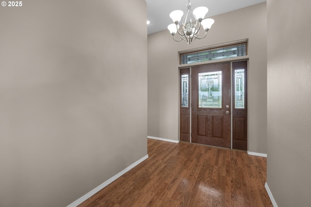 entrance foyer featuring an inviting chandelier, baseboards, and wood finished floors