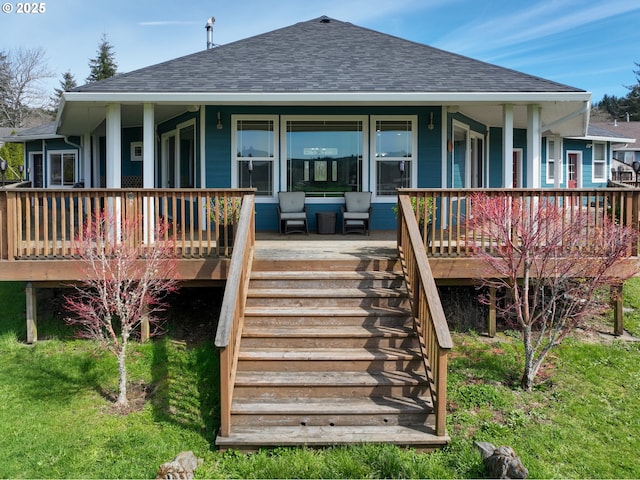 rear view of house with stairs and roof with shingles