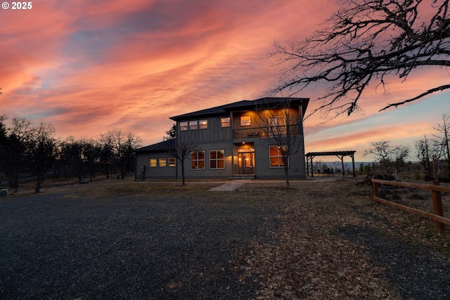 view of front of home with a balcony, fence, and board and batten siding