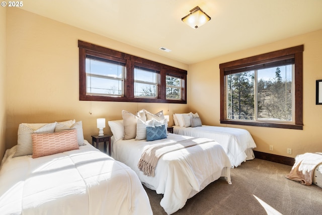 carpeted bedroom featuring visible vents and baseboards