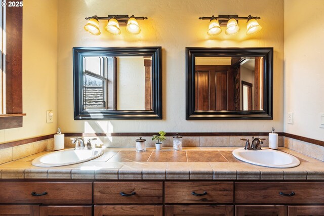 bathroom with a sink and double vanity