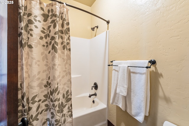 full bathroom featuring shower / bath combo and a textured wall