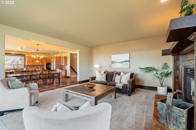 living area with a notable chandelier, a fireplace, recessed lighting, stairway, and baseboards