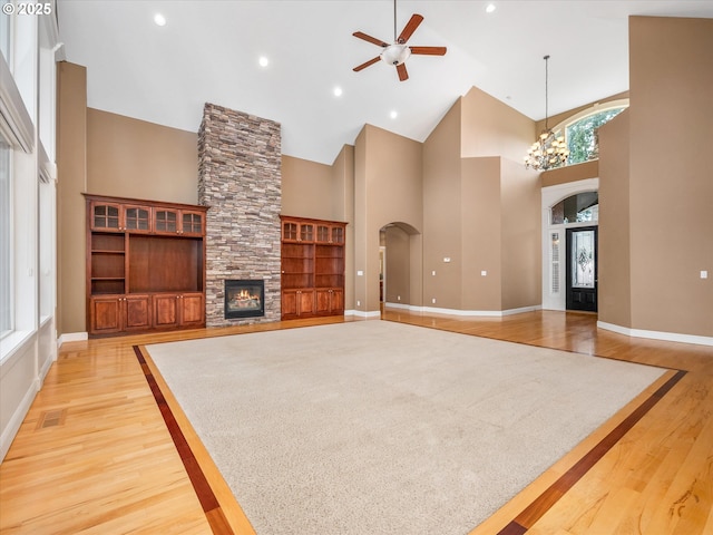 1303 NE 147th Ave, Vancouver, WA 98684 - unfurnished living room featuring arched walkways, ceiling fan, high vaulted ceiling, light wood finished floors, and a fireplace